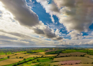 An aerial view of a field with clouds in the sky.