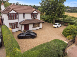 An aerial view of a house with a car parked in the driveway.
